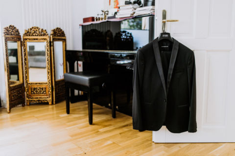 Hochzeitsfoto: Smoking hängt an der Tür bereit