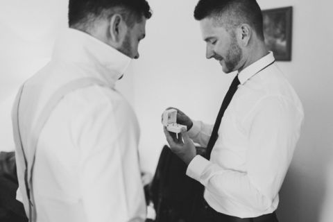 Bräutigam betrachtet Eheringe - Hochzeitsfoto