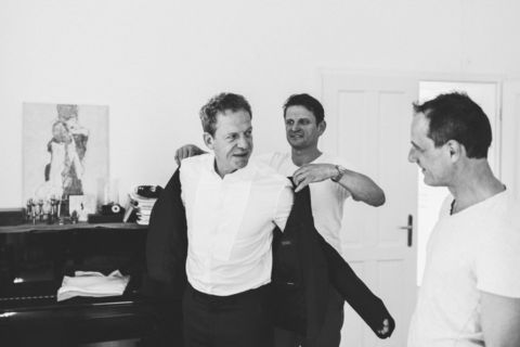 Bräutigam zieht Jacket an - Hochzeitsfoto