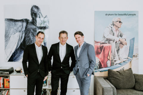 Ehemann und Trauzeugen mit Drykorn Bild im Hintergrund