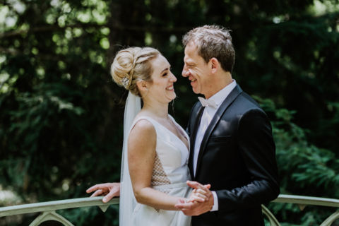 Hochzeitsfoto eines verliebten Ehepaares auf einer Brücke