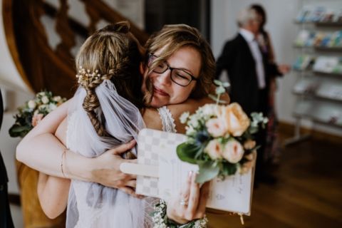 Foto von Braut und Blumenkind in Umarmung