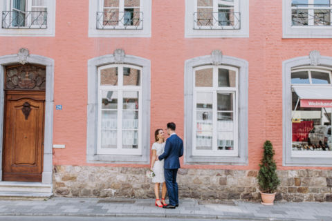 Hochzeitsfotografie Berlin: Brautpaar vor cremefarbenem Haus