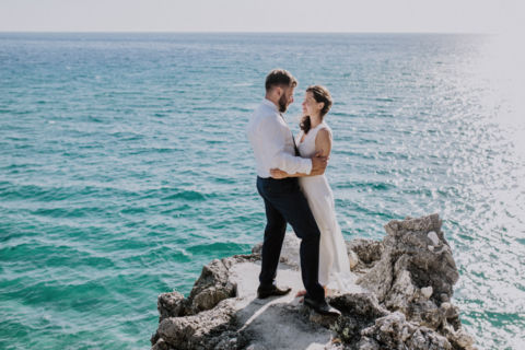 Ehepaar vor dem Meer auf Steinklippen - Hochzeitsfotografie
