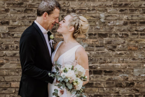 Fotoaufnahme des Ehepaars vor einer Backsteinwand