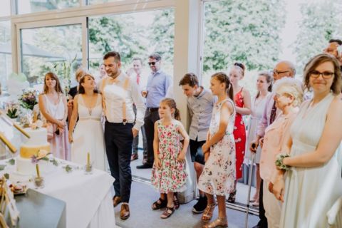 Fotoaufnahme der Hochzeitsgesellschaft vor der Torte