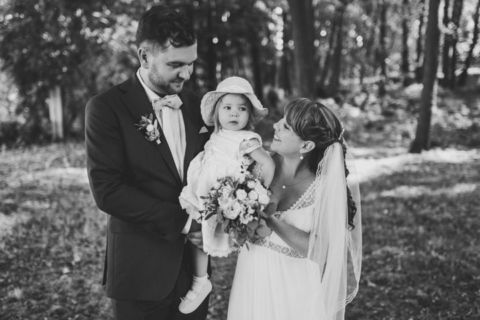 Schwarz-Weiß-Aufnahme des Brautpaars mit Kind