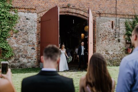 Hochzeitsfotografie Berlin: Ehepaar tritt aus Scheune