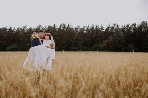 Foto im Kornfeld: Braut und Bräutigam küssen sich