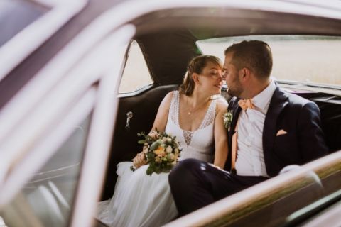 Fotoaufnahme des Brautpaares während Kuss im Mustang