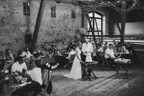 Hochzeitsfotograf Berlin: Schwarz-Aufnahme vom Anschneiden der Torte