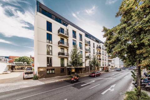 Fotografie eines Mehrfamilienhaus mit Straße in Berlin