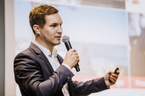 Lukas Schramm Fotografie - Eventfotograf - Berlin Fotoaufnahme eines Redners mit Mikrofon während einer Konferenz